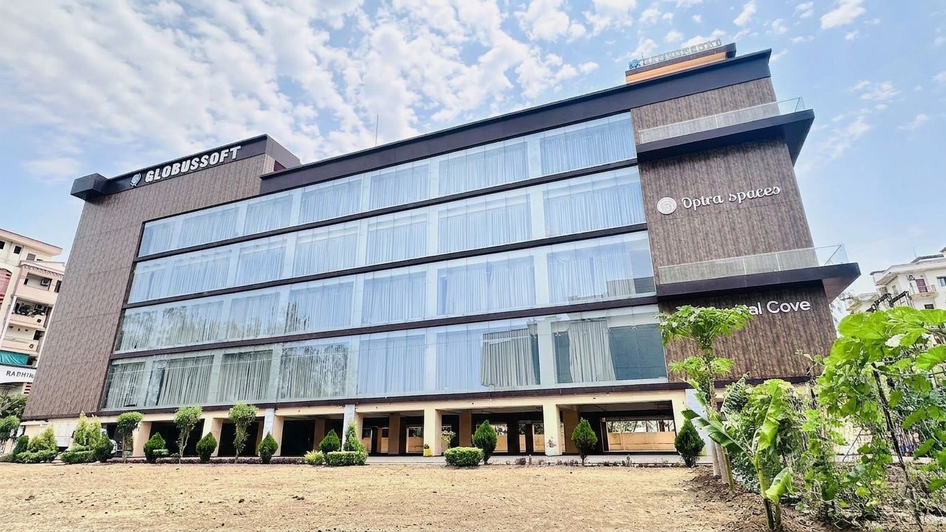 Three-quarter view of the same building showing the glazed elevation
                  down its long side and landscaped ground.